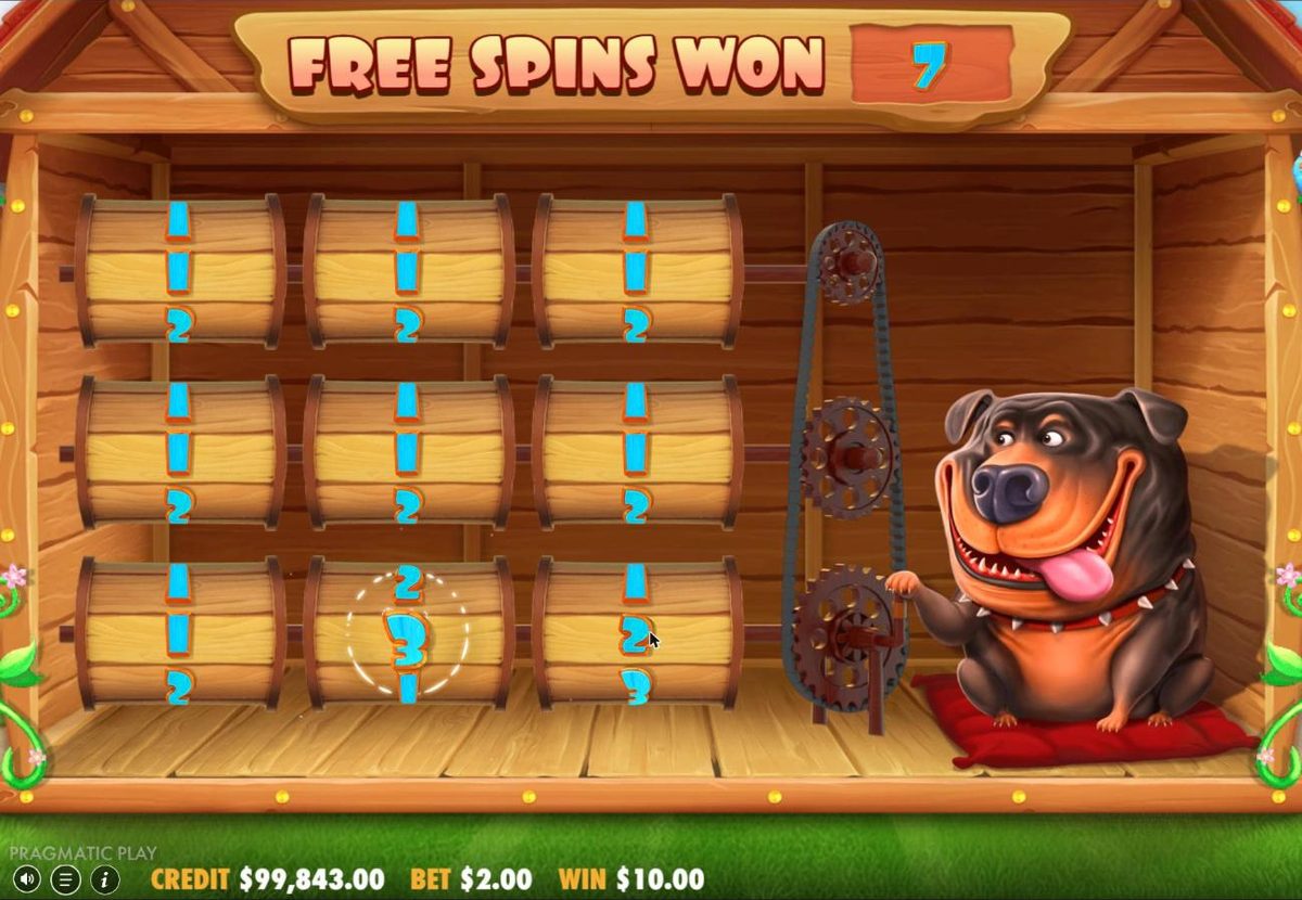 Before free spins: nine wooden barrels in a 3 by 3 grid inside the kennel, turned by the Rottweiler with a chain, while the counter at the top reads Free spins won 7 and still counting.